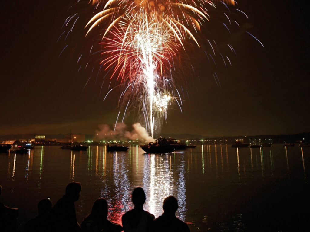 Fireworks shooting off of a boat on the water