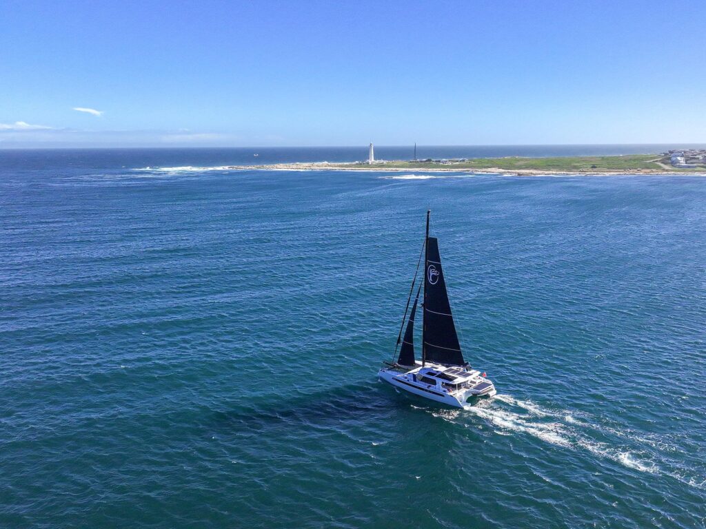 Balance 580 catamaran sailing near a lighthouse