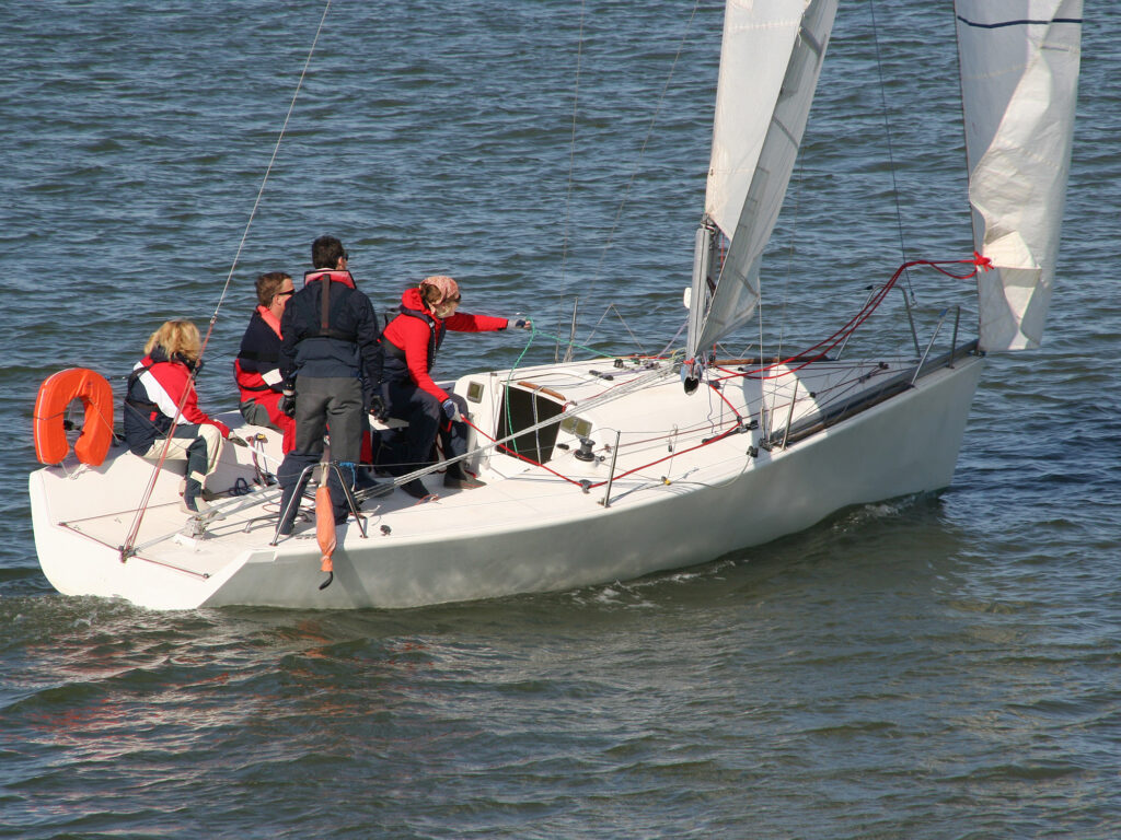 Sailing teacher with three students on a sailingboat at sea