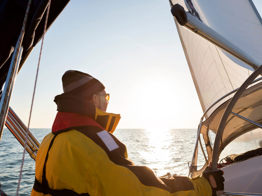 Man Wearing Waterproof Jacket On Yacht In Sea