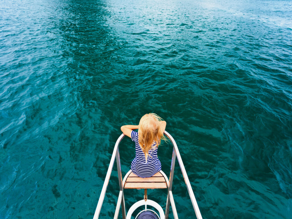Child on the bow of a sailboat