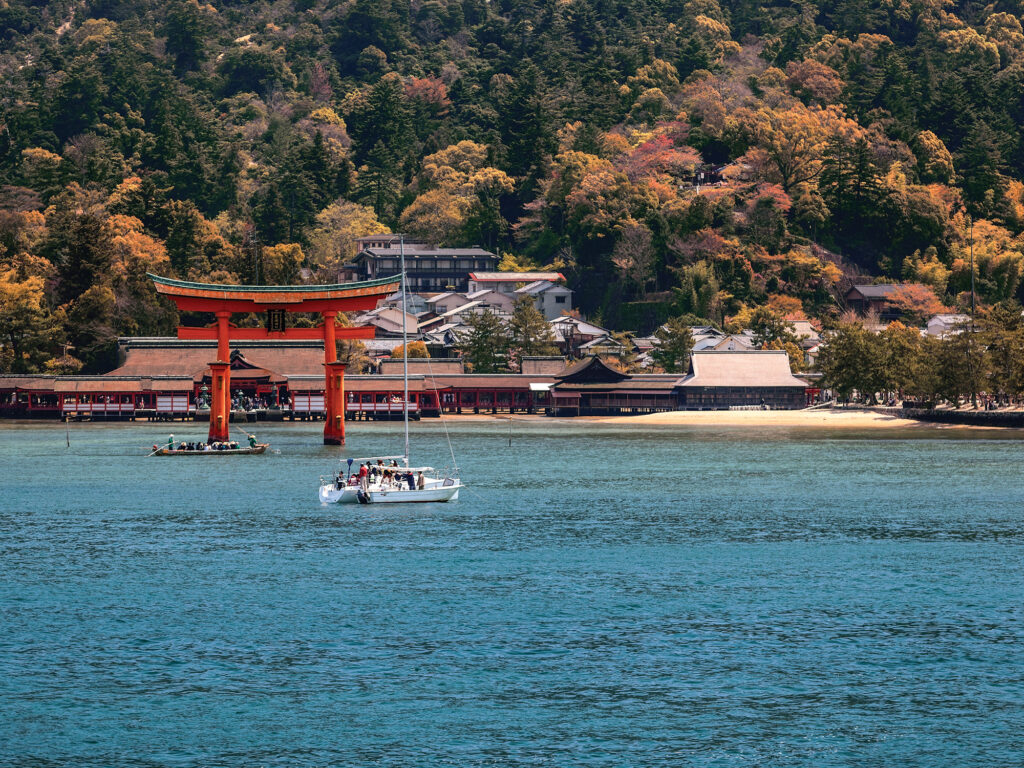 Sacred red Torii and Itsukushima Shinto shrine on the shore of the island of Miyajima, Japan. View from the Hiroshima gulf.