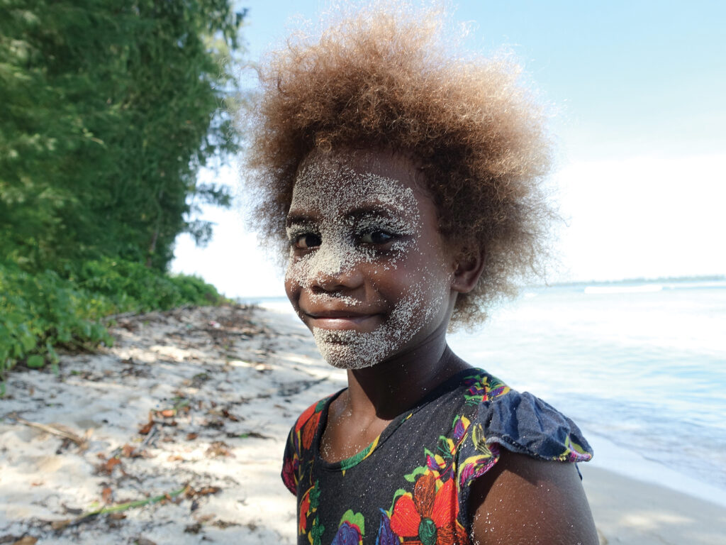 Child on the beach with sand on their face