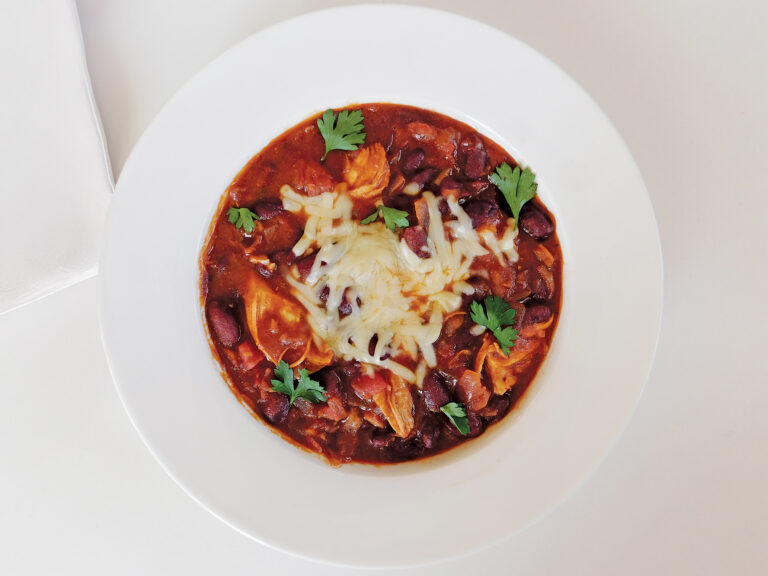 Bowl of chicken chili on a white table