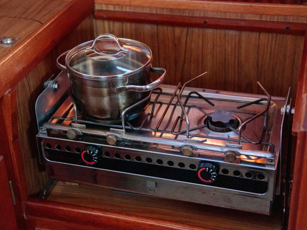 Cooking on the stainless stove on a sailing yacht in sailboat kitchen, sea life, old retro design