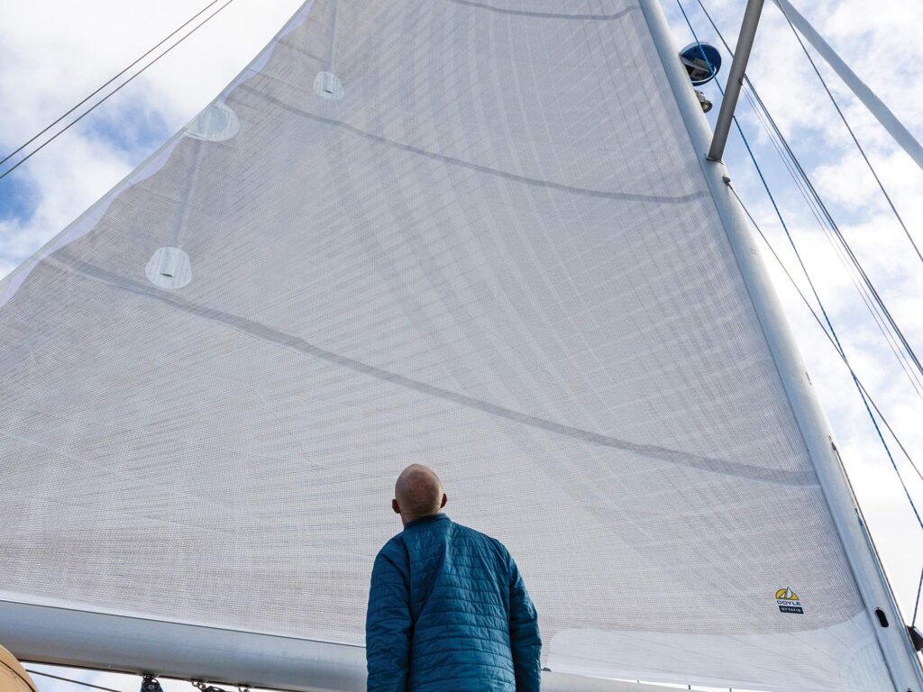 Man looking up at a sailboat sail